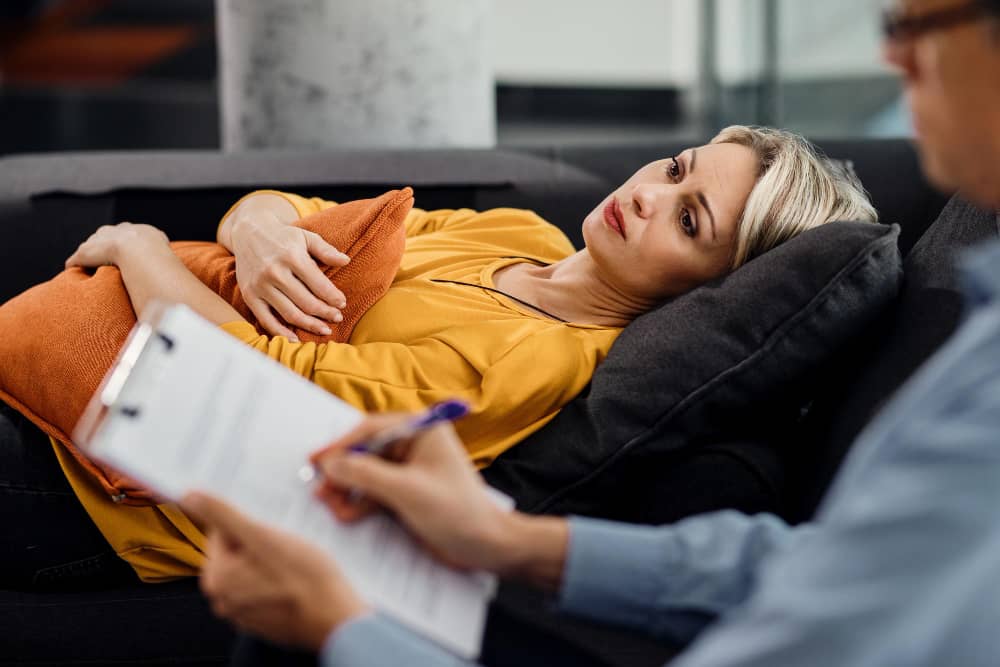 mujer pensativa acostada sofa psiquiatra cita su terapeuta (1)